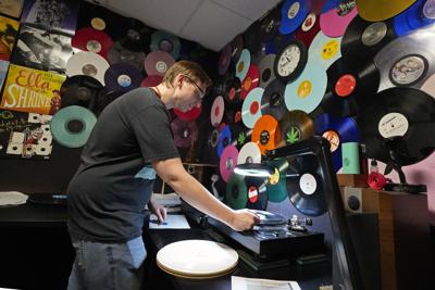 Tyler Bryant listens to finished record albums for flaws in a quality control room at the United Record Pressing facility Thursday, June 23, 2022, in Nashville, Tenn. The arrival of the compact disc nearly killed off record albums. Four decades later, with resuscitated record album sales producing double-digit growth, manufacturers are rapidly rebuilding an industry to keep pace with sales that topped $1 billion last year. (AP Photo/Mark Humphrey)