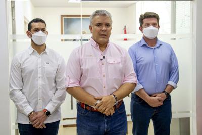 En esta foto difundida por la Presidencia de Colombia, habla el presidente Iván Duque, flanqueado por el ministro del Interior, Daniel Palacios, y el ministro de Defensa, Diego Molano, en Cúcuta, Colombia, el viernes 25 de junio de 2021. Duque dijo que el helicóptero en el que viajaban fue atacado en el Región del Catatumbo, en la frontera noreste con Venezuela. (Cesar Carrion/Presidencia de Colombia via AP)