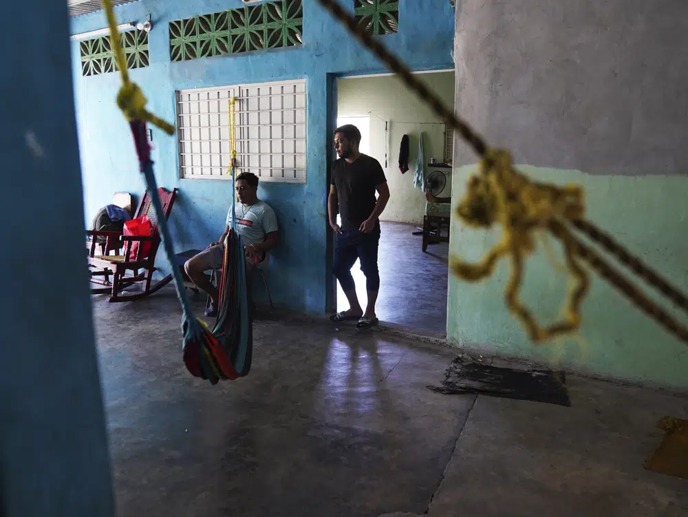 Migrantes descansan dentro de una casa cuyo dueño alquila habitaciones mientras esperan sus trámites migratorios en Tapachula, estado de Chiapas, México, el lunes 3 de octubre de 2022. Un taxista local alquila el espacio a los migrantes por 100 pesos la noche, unos 5 dólares. (AP Foto/Marco Ugarte)