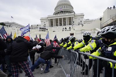 ARCHIVO - Partidarios del presidente saliente Donald Trump tratan de atravesar una barrera policial en el Capitolio, Washington, 6 de enero de 2021. Un hombre que estacionó una camioneta cargada de armas y bombas Molotov cerca del Capitolio durante la insurrección del año pasado fue condenado a casi cuatro años de prisión el viernes 1 de abril de 2022. (AP Foto/Julio Cortez, File)