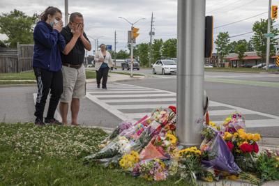 Gente asiste a un monumento improvisado en el lugar donde el conductor de una camioneta atropelló a una familia de cinco en London, Ontario, Canadá, 7 de junio de 2021. Cuatro miembros de la familia murieron y uno se encuentra en estado crítico. Un hombre de 20 años está acusado de cuatro cargos de homicidio agravado y uno de intento de homicidio. (Brett Gundlock/The Canadian Press via AP)