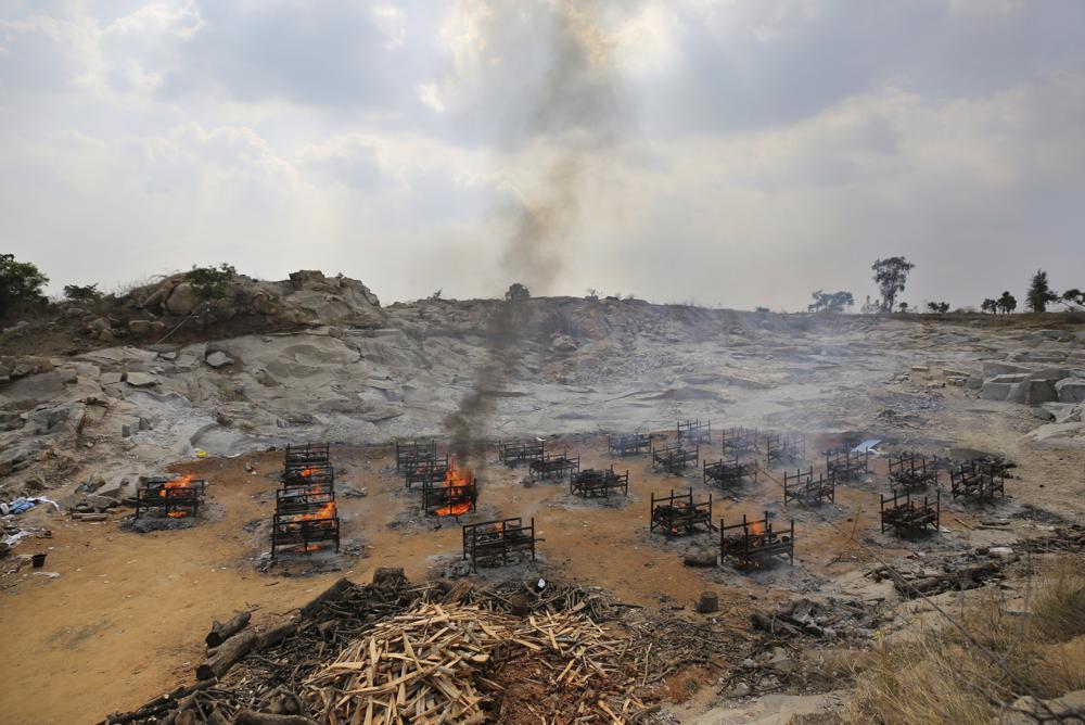 FILE - In this May 5, 2021, file photo, funeral pyres of twenty-five COVID-19 victims burn at an open crematorium set up at a granite quarry on the outskirts of Bengaluru, India. Indias excess deaths during the pandemic could be a staggering 10 times the official COVID-19 toll, likely making it modern Indias worst human tragedy, according to the most comprehensive research yet on the ravages of the virus in the south Asian country. (AP Photo/Aijaz Rahi, File)