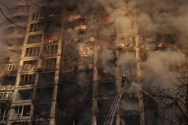 Los bomberos extinguen las llamas en un edificio de apartamentos después de ser alcanzados por los bombardeos en Kiev, Ucrania, el martes 15 de marzo de 2022. (AP Foto/Felipe Dana)