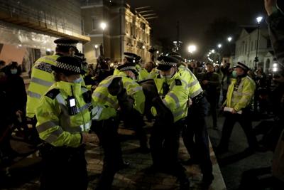 Los agentes de policía retienen a un hombre después de que le dijeron a la gente que se fuera a casa durante una marcha para reflexionar sobre el asesinato de la ejecutiva de marketing de 33 años, Sarah Everard, en Londres, el 15 de marzo de 2021. La forma en que la policía manejó una vigilia en memoria de una mujer asesinada, celebrada durante el confinamiento por el coronavirus en Gran Bretaña, violó los derechos de los organizadores a la libertad de expresión y reunión, dictaminó un tribunal el viernes 11 de marzo de 2022. La vigilia de protesta fue convocada después de que Sarah Everard, una mujer londinense de 33 años, fuera secuestrada y asesinada en marzo de 2021 por un oficial de la Policía Metropolitana fuera de servicio mientras caminaba a casa por la noche. (AP Photo/Matt Dunham)