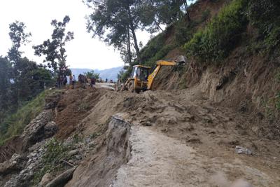 Una excavadora ayuda a despejar un camino luego de un alud provocado por las fuertes lluvias en Dipayal Silgadhi, Nepal, el jueves 21 de octubre de 2021. (AP Foto/Laxmi Prasad Ngakhusi)