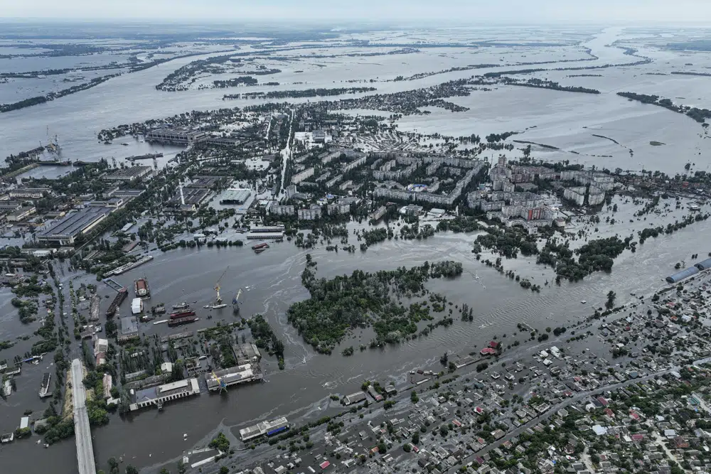Houses are seen underwater and polluted by oil in a flooded neighborhood in Kherson, Ukraine, Saturday, June 10, 2023. Extensive flooding from the catastrophic destruction of the Kakhovka Dam on June 6 devastated towns along the lower Dnieper River in the embattled Kherson region. Russia and Ukraine accuse each other of causing the breach. (AP Photo/Evgeniy Maloletka)