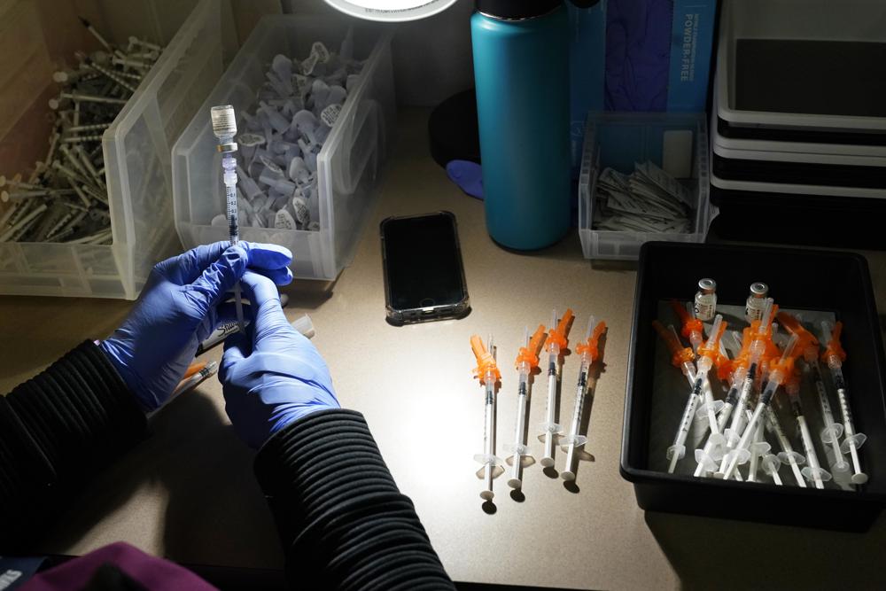 FILE - In this June 3, 2021, file photo, registered nurse fills syringes with Pfizer vaccines at a COVID-19 vaccination clinic at PeaceHealth St. Joseph Medical Center, in Bellingham, Wash. The U.S. death toll from COVID-19 has topped 600,000, even as the vaccination drive has drastically slashed daily cases and deaths and allowed the country to emerge from the gloom. (AP Photo/Elaine Thompson, File)