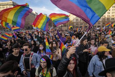 Personas ondean banderas de arcoíris al paso de los carros alegóricos durante una marcha por la diversidad sexual, en Santiago, Chile, el sábado 25 de junio de 2022. (AP Foto/Esteban Felix)