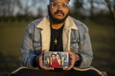 Adam Almonte muestra una foto en la que se lo ve con su hermano mayor, Fernando Morales, el 16 de marzo del 2022 en un parque de Nueva York. Fernando falleció por el COVID-19 en abril del 2020. (AP Photo/David Goldman)