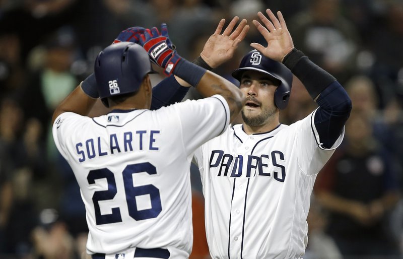 San Diego Padres' Yangervis Solarte, left, and Austin Hedges congratulate each other for scoring on a two-run double by Erick Aybar against the Arizona Diamondbacks during the fifth inning of a baseball game in San Diego, Thursday, April 20, 2017. (AP Photo/Alex Gallardo)