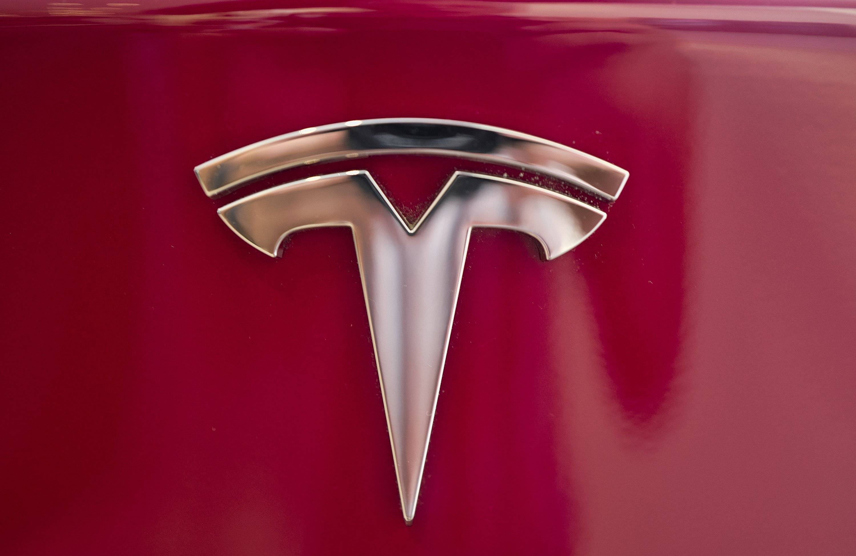 Знак теслы на машине. Тесла эмблема. Логотип Tesla 2022. Значок Тесла машины. Тесла значок на капоте.