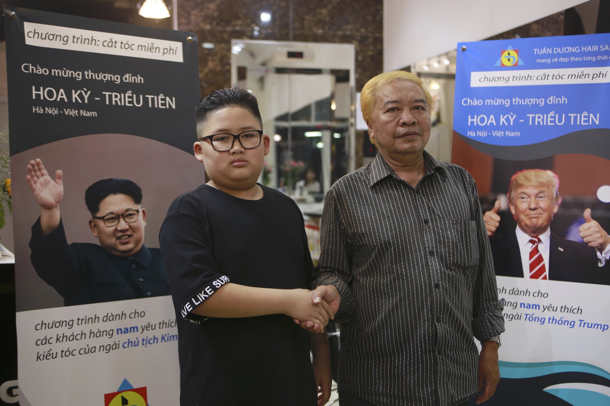 Le Phuc Hai, 66 and To Gia Huy, 9, pose for a photo after having Trump and Kim haircuts in Hanoi, Vietnam, on Tuesday, Feb.19, 2019. U.S. President Donald Trump and North Korean leader Kim Jong Un have become the latest style icons in Hanoi, a week before their second summit is to be held in the capital city of Vietnam.(AP Photo/Hau Dinh)