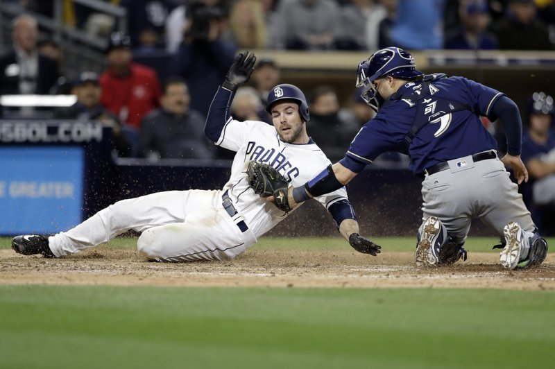 Milwaukee Brewers catcher Manny Pina tags out San Diego Padres’ Matt Szczur during the seventh inning of a baseball game Tuesday, May 16, 2017, in San Diego. (AP Photo/Gregory Bull)