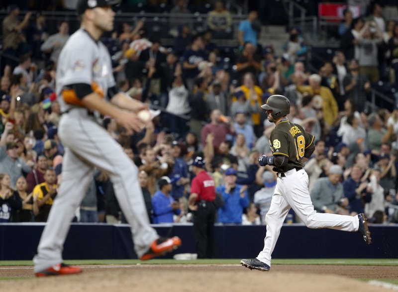 Miami Marlins pitcher David Phelps waits as San Diego Padres' Austin Hedges, right, rounds third base after hitting a three-run home run during the seventh inning of a baseball game in San Diego, Friday, April 21, 2017. (AP Photo/Christine Cotter)