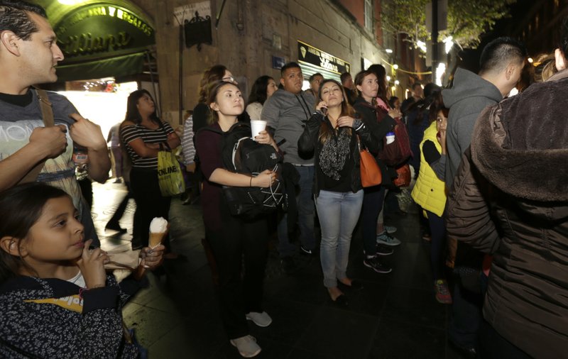 In this Dec. 22, 2016 photo, Mexican youth who migrated to the U.S. as children walk through downtown Mexico City, on their first night back in their native country. More than 100 former child migrants have visited the country of their birth on five such trips sponsored by California State University, Long Beach, emotional journeys to what is often a barely remembered homeland, to reunite with family seen only in photos or on Skype. (AP Photo/Marco Ugarte)