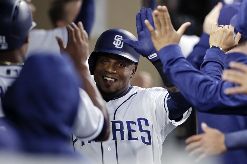 San Diego Padres' Erick Aybar is greeted by teammates after scoring on a two-RBI double by Hunter Renfroe during the second inning of a baseball game against the Milwaukee Brewers, Monday, May 15, 2017, in San Diego. (AP Photo/Gregory Bull)