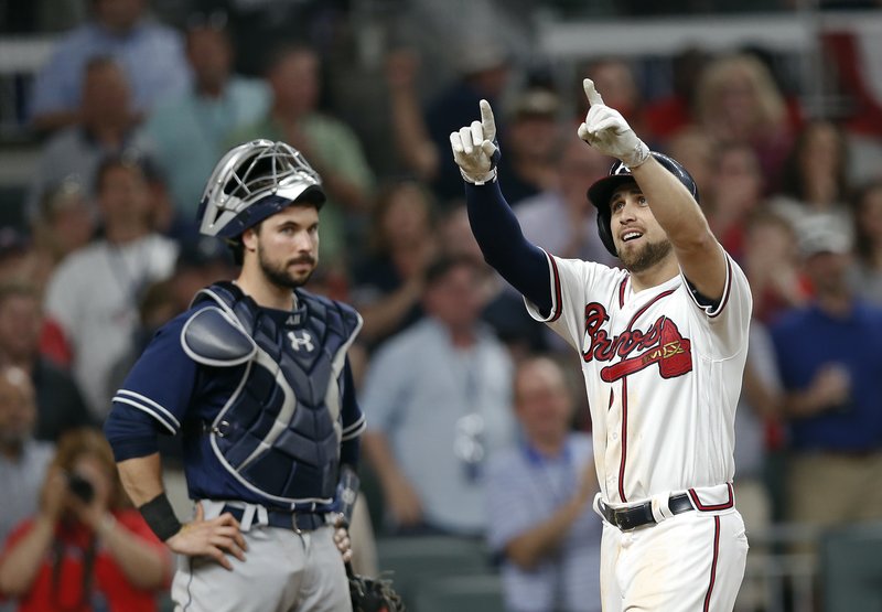 Atlanta Braves' Ender Inciarte, right, gestures as he crosses home plate in front of San Diego Padres catcher Austin Hedges, left, after hitting a two-run home run in the sixth inning of a baseball game Friday, April 14, 2017, in Atlanta. The home run was the first hit in Sun Trust Park. (AP Photo/John Bazemore)