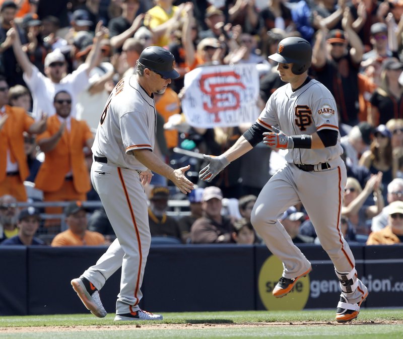 San Francisco Giants' third base coach Phil Nevin, left, congratulates Buster Posey for hitting a solo home run against the San Diego Padres during the third inning of a baseball game in San Diego, Sunday, April 9, 2017. (AP Photo/Alex Gallardo)