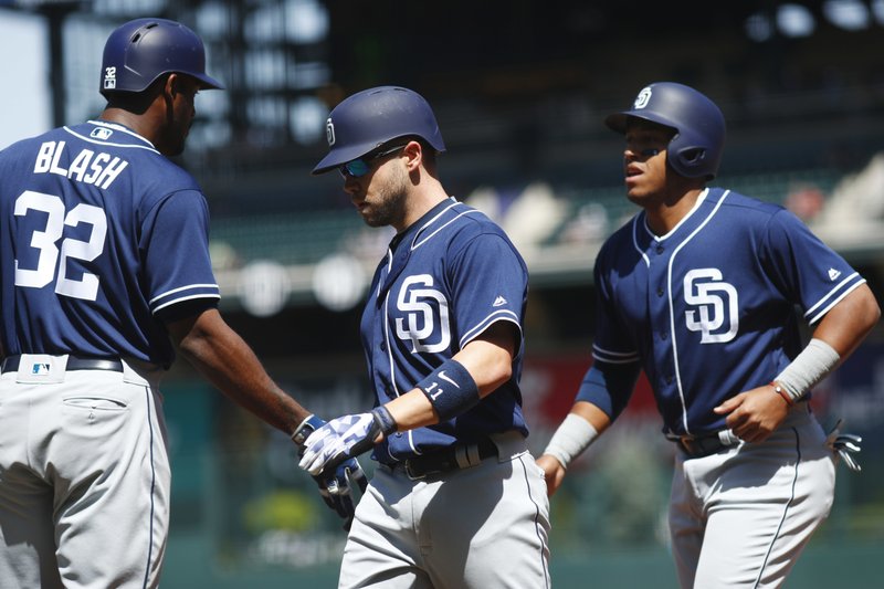 From left, San Diego Padres' Jabari Blash congratulates Ryan Schimpf after he hit a two-run home run to drive in Yangervis Solarte against the Colorado Rockies starting pitcher Kyle Freeland in the first inning of a baseball game Wednesday, April 12, 2017, in Denver. (AP Photo/David Zalubowski)