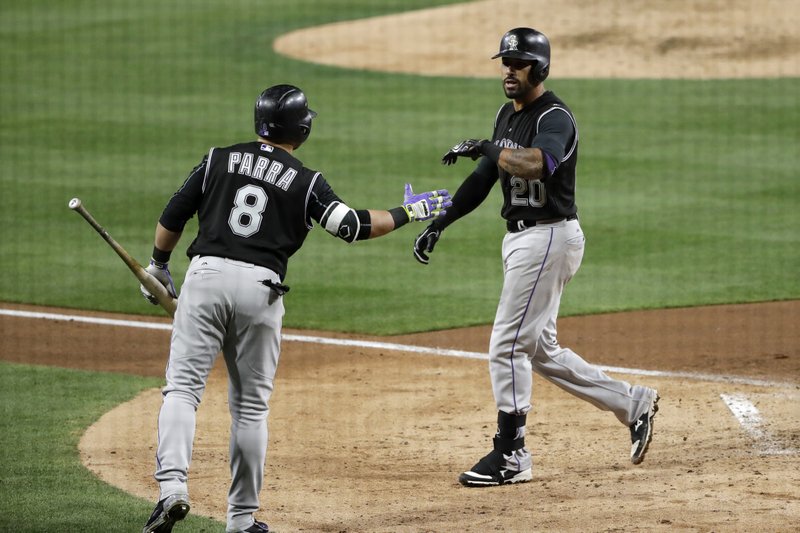 Colorado Rockies' Ian Desmond, right, is greeted by Gerardo Parra after hitting a home run during the fifth inning of a baseball game against the San Diego Padres on Wednesday, May 3, 2017, in San Diego. (AP Photo/Gregory Bull)