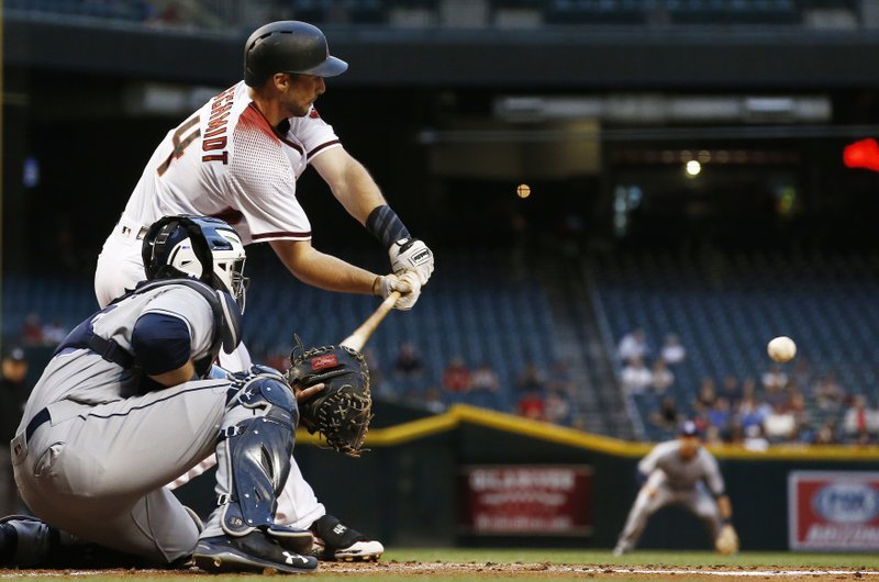 Arizona Diamondbacks' Paul Goldschmidt, top, reaches out with his bat before connecting on a run-scoring single as San Diego Padres' Austin Hedges, bottom, watches during the first inning of a baseball game, Wednesday, April 26, 2017, in Phoenix. (AP Photo/Ross D. Franklin)