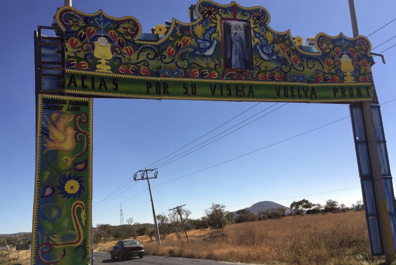 This Dec. 23, 2016 photo shows an arch welcoming visitors to Molcaxac, Puebla state, Mexico. Folks here say so many working-age residents have migrated to the U.S., the town is mostly populated by the elderly and the very young. The first wave of migration started in 1942 with the bracero program, which allowed Mexicans to temporarily, and legally, work in the United States. After the program ended in 1964, people continued to go north illegally. (AP Photo/Peter Orsi)