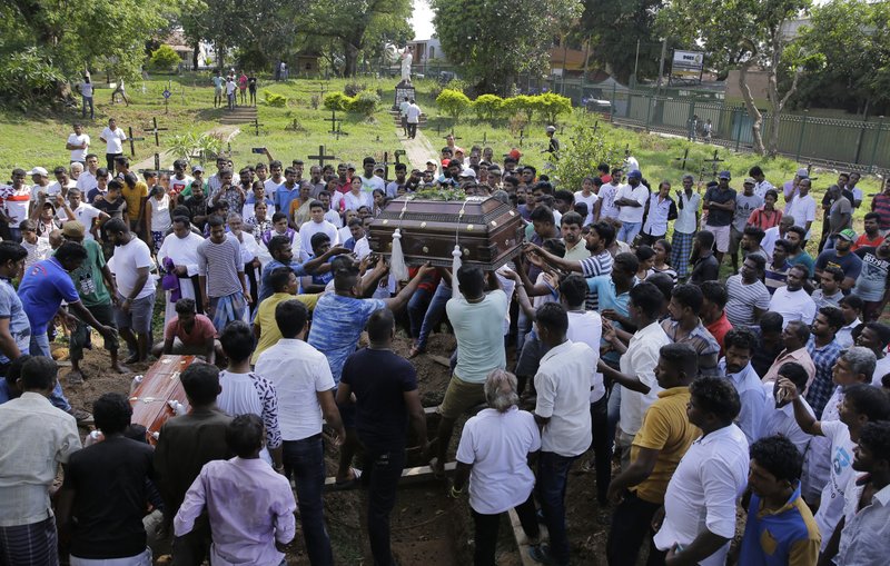 The coffins of three members of the Gomez family are carried for burial in side-by-side graves in Colombo, Sri Lanka. The family lost five loved ones in the Easter Sunday bombings. (Credit: Eranga Jayawardena/AP.)