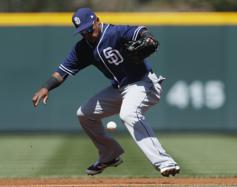 San Diego Padres' shortstop Erick Aybar juggles the ball after fielding a ground ball hit by Colorado Rockies' Carlos Gonzalez in the first inning of a baseball game Wednesday, April 12, 2017, in Denver. Akbar went on to put out Gonzalez. (AP Photo/David Zalubowski)