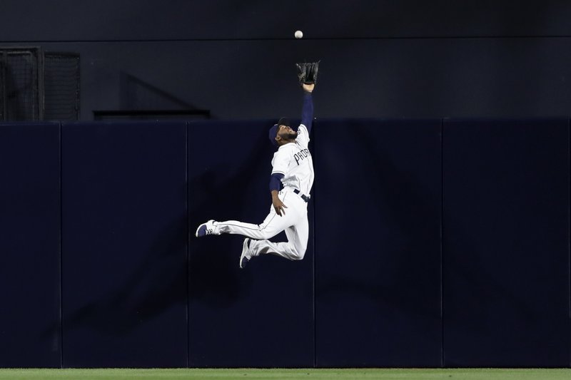 San Diego Padres center fielder Manuel Margot leaps but misses a home run hit by the Milwaukee Brewers’ Jesus Aguilar during the sixth inning of a baseball game, Monday, May 15, 2017, in San Diego. (AP Photo/Gregory Bull)