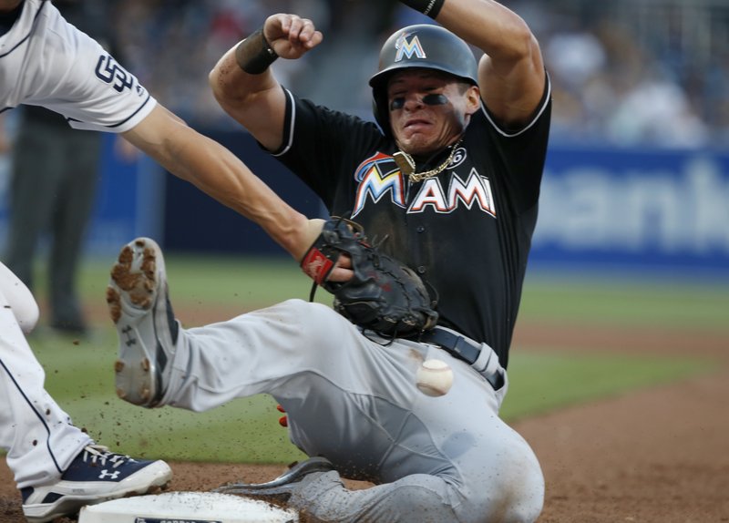 Miami Marlins' Derek Dietrich, right, avoids a pickoff-attempt by San Diego Padres first baseman Wil Myers in the fifth inning of a baseball game in San Diego, Saturday, April 22, 2017. (AP Photo/Christine Cotter)