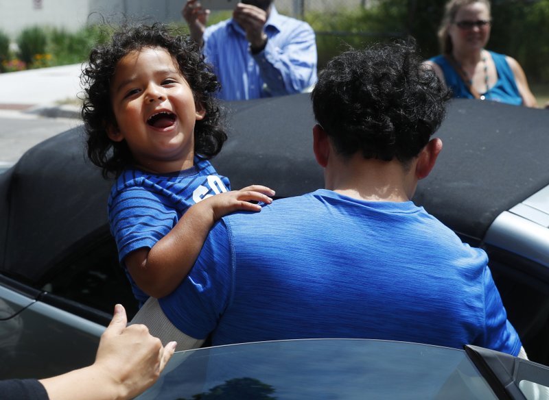 reunited immigrant children scooped up into parents arms