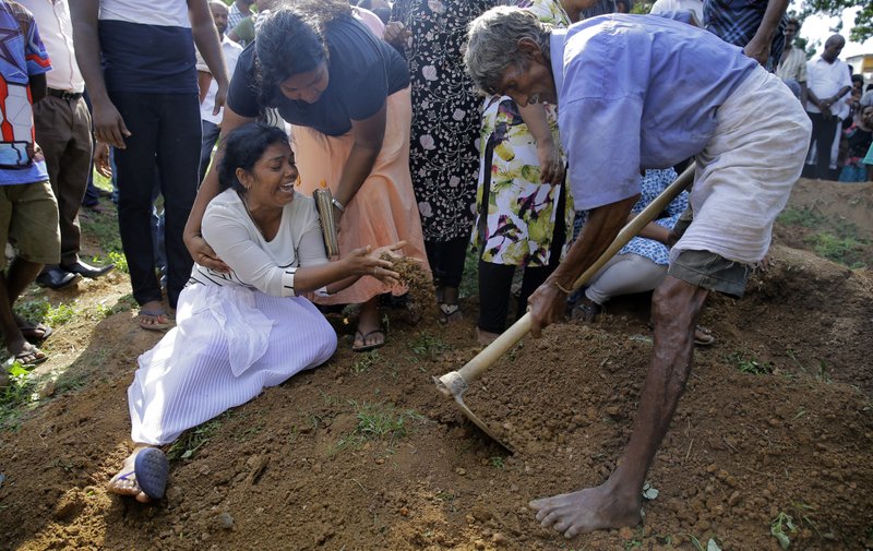 Wasanthi, a member of the Gomez family weeps over the gave of 9-year-old Bevon, who was killed in the Easter Sunday bombings in Colombo, Sri Lanka. (Credit: Eranga Jayawardena/AP.)