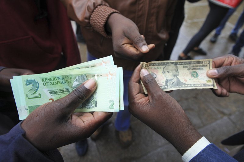 Zimbabwe Issues New Currency Bond Notes Zimbabweans Compare The New Note With Us Dollar Following Introduction Of Notes By Reserve Bank Zimbabwe In Harare Monday Nov 28