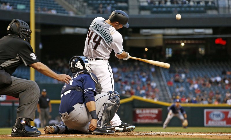 Arizona Diamondbacks' Paul Goldschmidt connects for a home run as San Diego Padres' Austin Hedges, middle, and umpire Gary Cederstrom, left, look on during the first inning of a baseball game Tuesday, April 25, 2017, in Phoenix. (AP Photo/Ross D. Franklin)