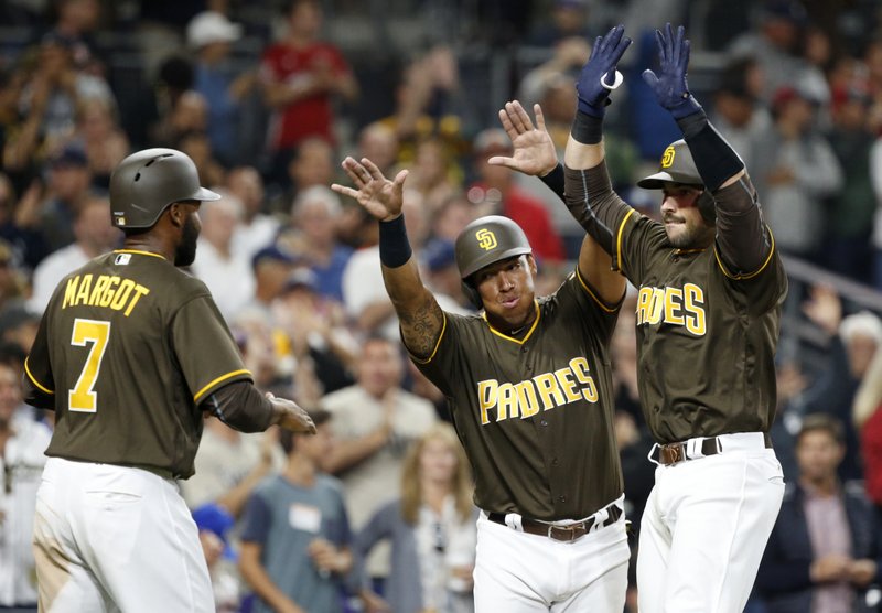 San Diego Padres catcher Austin Hedges, right, celebrates his three-run home run with teammates Manuel Margot, left, and Yangervis Solarte during the seventh inning of a baseball game against the Miami Marlins in San Diego, Friday, April 21, 2017. (AP Photo/Christine Cotter)