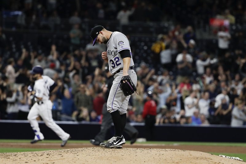 Colorado Rockies starting pitcher Tyler Chatwood (32) waits as San Diego Padres' Ryan Schimpf rounds the bases after hitting a home run during the sixth inning of a baseball game Tuesday, May 2, 2017, in San Diego. (AP Photo/Gregory Bull)