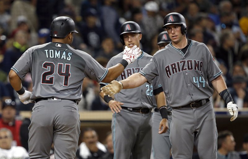 Arizona Diamodbacks' Paul Goldschmidt, right, congratulates Yasmany Tomas for hitting a three-run home run to score Jake Lamb, center, and Goldschmidt against the San Diego Padres during the fifth inning of a baseball game in San Diego, Tuesday, April 18, 2017. (AP Photo/Alex Gallardo)