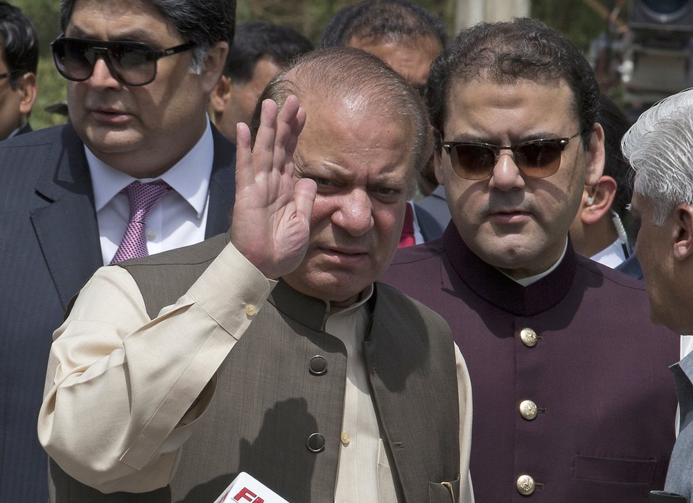  In this Thursday, June 15, 2017, photo, Pakistani Prime Minister Nawaz Sharif waves with his son Hussain Nawaz, right, outside the premises of the Joint Investigation Team, in Islamabad, Pakistan. Pakistan's Supreme Court in a unanimous decision has asked the country's anti-corruption body to file corruption charges against Prime Minister Nawaz Sharif, his two sons and daughter for concealing their assets. (AP Photo/B.K. Bangash) 