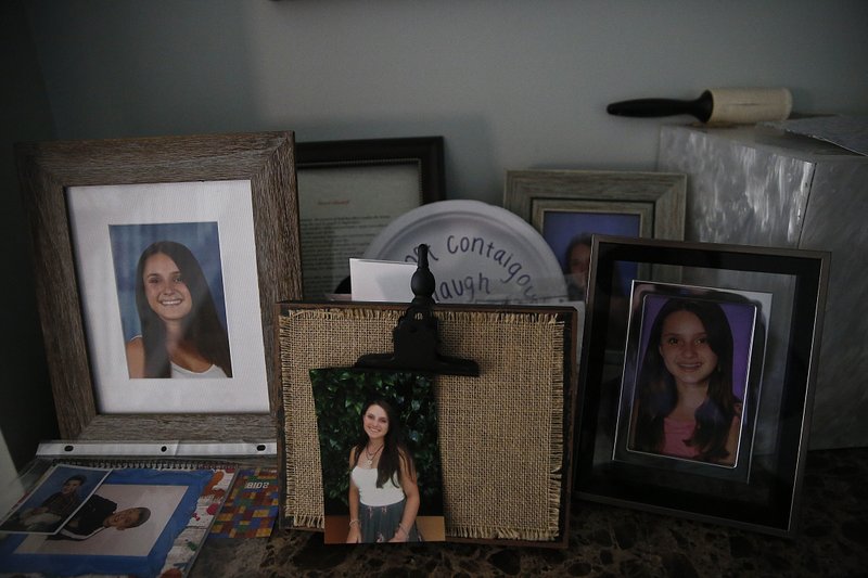 Photographs of Alyssa Alhadef, sit on a table in her home on Wednesday, Jan. 30, 2019, in Parkland, Florida. (AP Photo/Brynn Anderson)