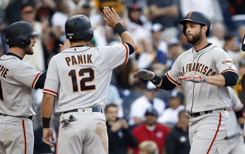 San Francisco Giants' Conor Gillespie, left, and Joe Panik congratulate Brandon Belt, right, after his grand slam against the San Diego Padres during the fifth inning of a baseball game in San Diego, Friday, April 7, 2017. (AP Photo/Alex Gallardo)