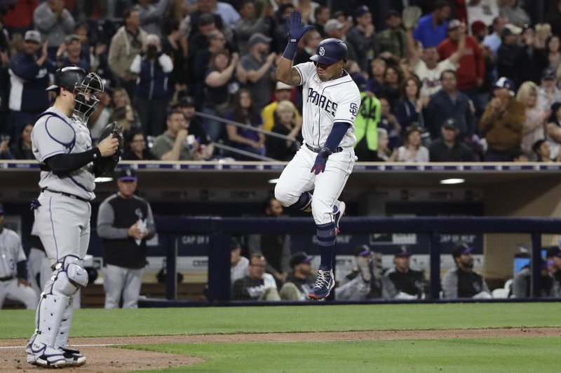 San Diego Padres' Yangervis Solarte, right, reacts after hitting a two-run home run as Colorado Rockies catcher Tony Wolters waits at left, during the sixth inning of a baseball game Tuesday, May 2, 2017, in San Diego. (AP Photo/Gregory Bull)