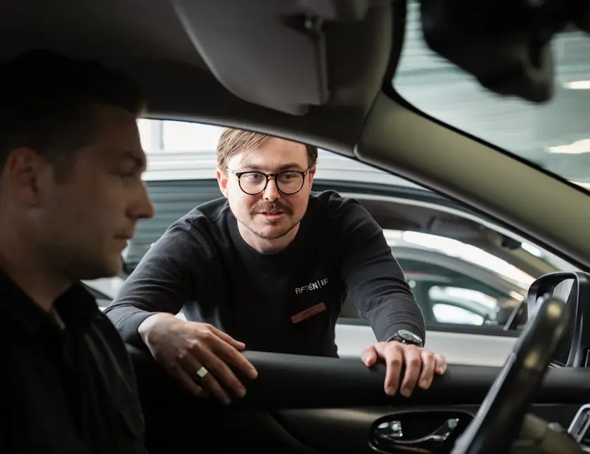 Aftén Bil-säljare introducerar en bil för en kund