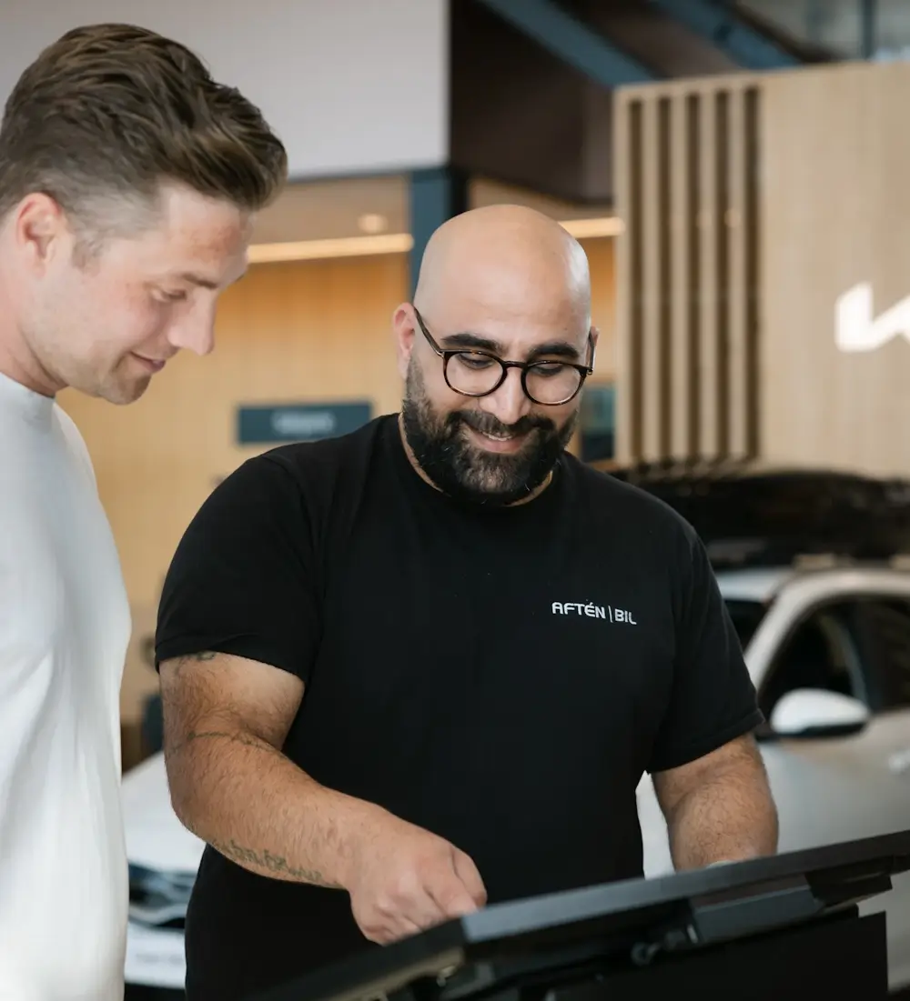 Säljare och kund pratar om bilen i Aftén Bils bilhall