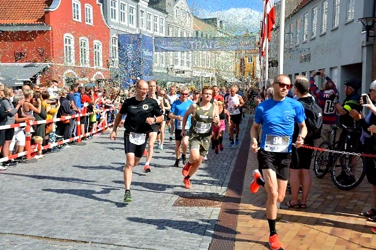 Løbere i en bymaraton med konfetti.