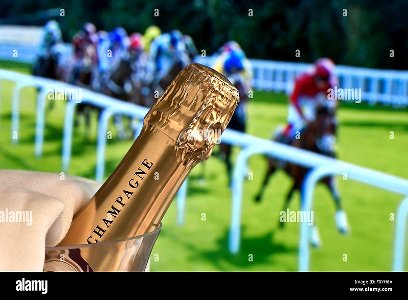 Champagneflaske foran sløret billede af hestevæddeløb. Relateret til Champagnegaloppen.