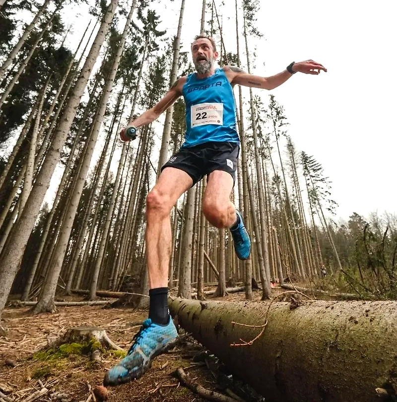 Løber springer over træstamme i skov. #CopenhagenExhaustTrail