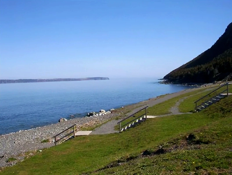 Smukt billede af kyststien med trapper ned til en stenet strand.