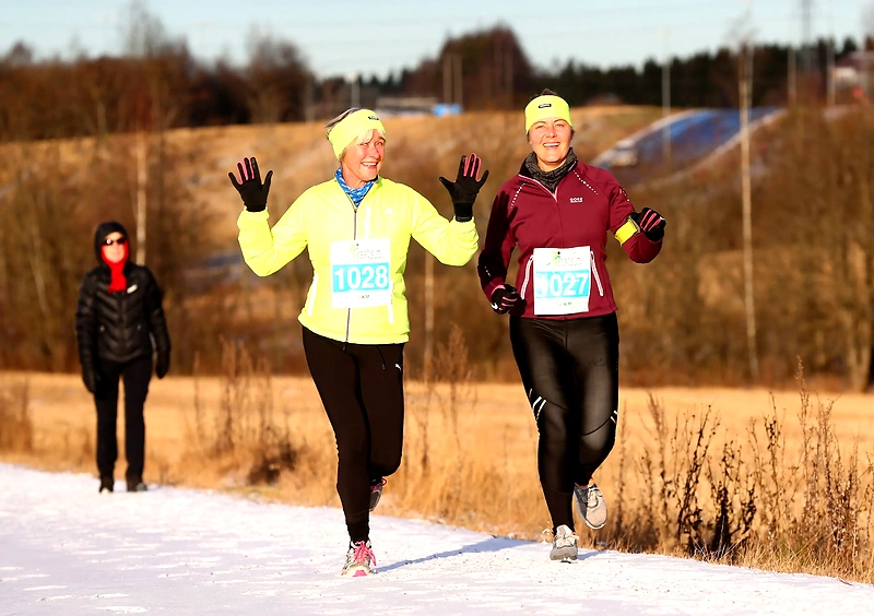 To glade kvinder løber vintermaraton.