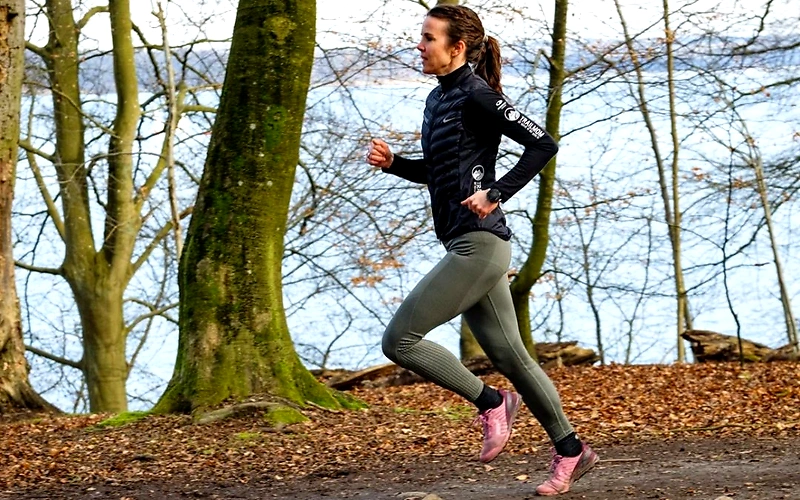 Løb i skoven - flot billede af en kvinde der løber trail.