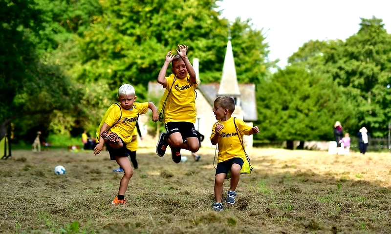 Børn i gule t-shirts løber glad i Junglerun.